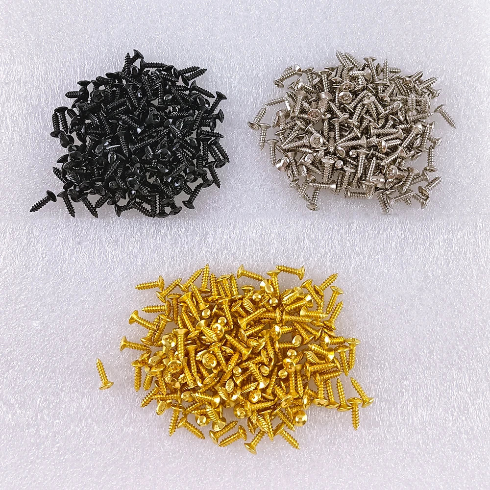 Three piles of pickguard screws in black, silver and gold finishes.